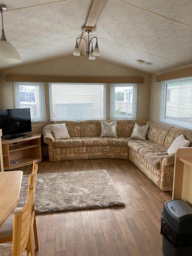 a living room with a couch and a tv at MV194 Golden Palm Resort in Chapel Saint Leonards