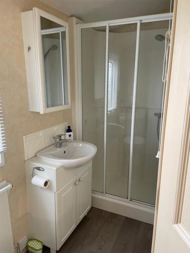 une salle de bain avec un lavabo blanc et une douche dans l'établissement Golden Palm Resort MV194, à Chapel St. Leonards