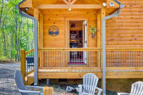 a wooden cabin with two chairs and a porch at Mountain View and Fire Pit Updated Murphy Cabin! in Murphy