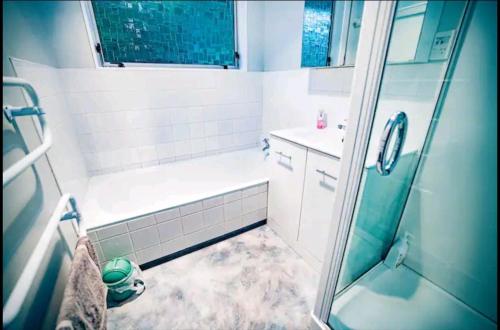 a bathroom with a shower and a tub and a sink at Warm, tidy , quiet vacation home in Wellington