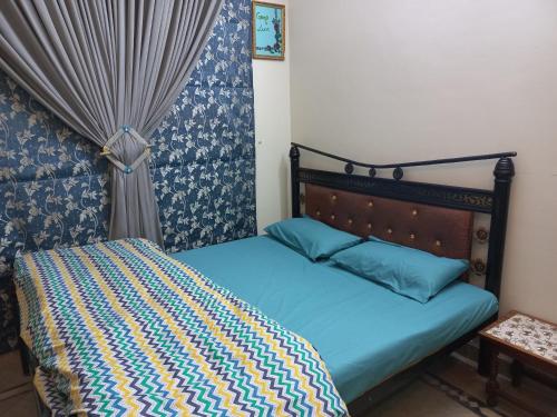 a bed with a blue comforter in a bedroom at 3 Bedroom House right In-between Twin Cities in Rawalpindi