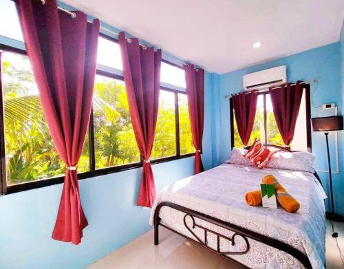 a bedroom with a bed with red curtains and windows at Family Friendly Entire House 4 minutes to Beach in Liloan