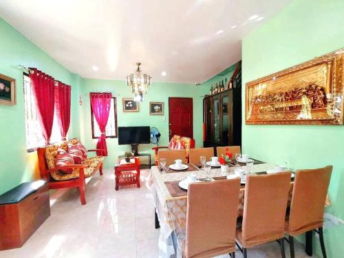 a dining room with a table and chairs and a living room at Family Friendly Entire House 4 minutes to Beach in Liloan