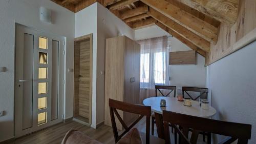a dining room with a table and chairs and a window at Iva Lux Apartments in Žabljak
