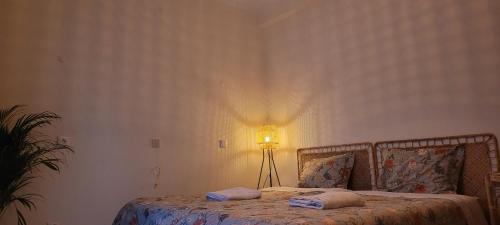 a bedroom with a bed with a lamp on it at Bela Alexandra Guest House in Fuzeta
