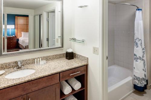 a bathroom with a sink and a tub and a mirror at Residence Inn Phoenix North Happy Valley in Phoenix