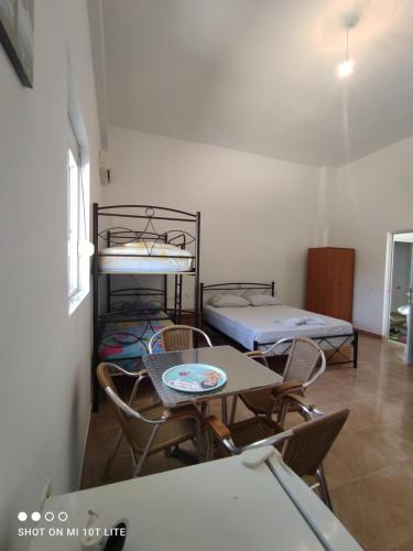 a room with two bunk beds and a table and chairs at IONIAN PEARL in Borsh