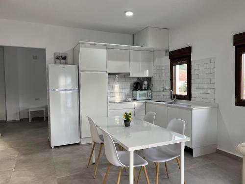 a kitchen with a white table and white appliances at Apartamentos Torreón de Manuela in La Calahorra
