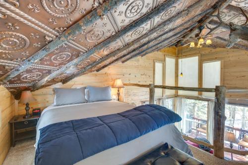 a bedroom with a bed in a room with wooden ceilings at Idaho Springs Cabin with Hot Tub on Half Acre! in Idaho Springs