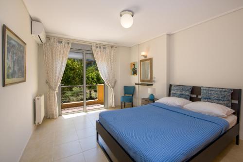 a bedroom with a blue bed and a large window at Gea Maleme in Maleme