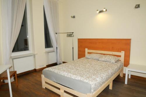 1 dormitorio con 1 cama y 2 ventanas en Economic Mandala Apartment en Poznan