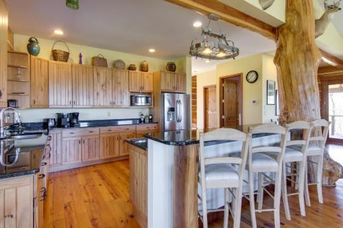 a kitchen with wooden cabinets and a bar with stools at Mountain View and Fire Pit Rustic Marshall Getaway! in Marshall