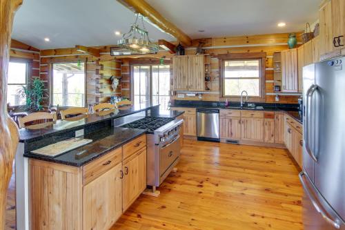 a kitchen with wooden cabinets and a stainless steel refrigerator at Mountain View and Fire Pit Rustic Marshall Getaway! in Marshall