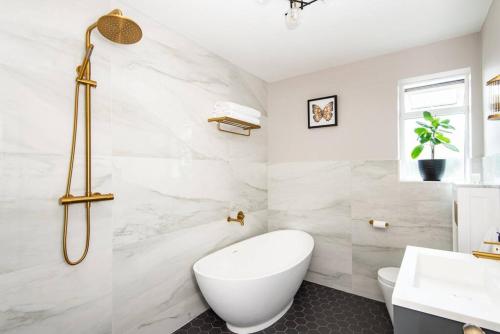 a bathroom with a white tub and a sink at Newly renovated Victorian house with free parking in Portslade