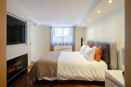 a bedroom with a large bed with a tv on it at Charming Apt in Historic House in Coimbra