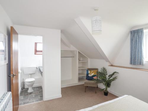 a white bathroom with a toilet and a sink at Ysgo - 6 Ty'n Don in Abersoch