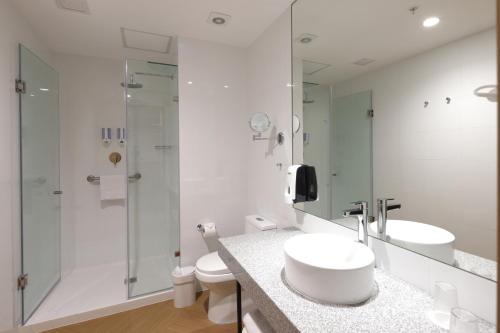 a white bathroom with a sink and a shower at Casa Andina Standard Benavides in Lima