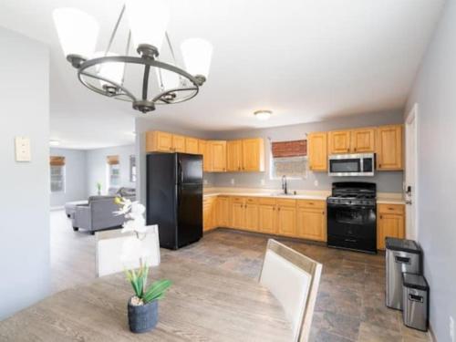 a kitchen with wooden cabinets and a black refrigerator at Gorgeous Waterfront 2:1 - 2 houses in 1 building. in New Haven