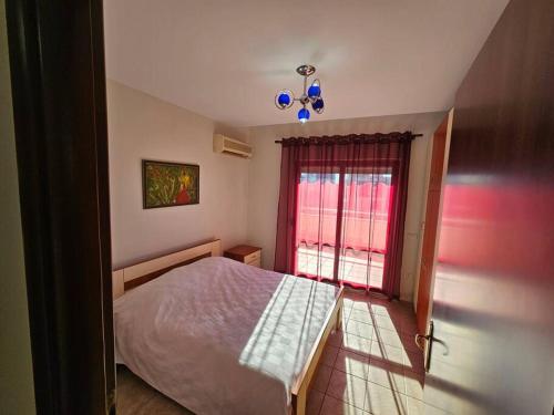 1 dormitorio con cama y ventana en Central Apartment, en Tirana