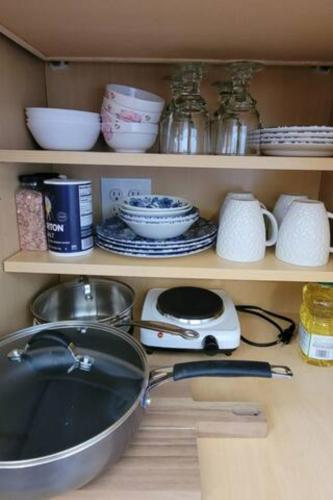 a kitchen counter with a sink and dishes on shelves at Private entry 2b1b guest suite in San Jose