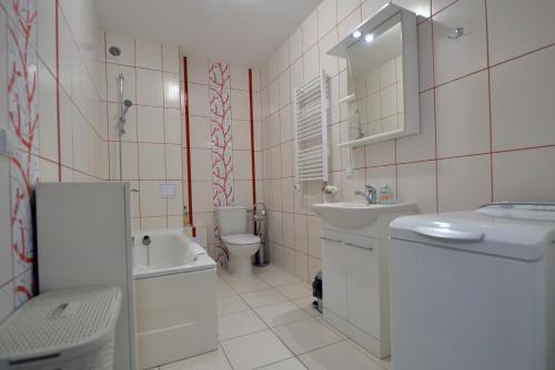 a bathroom with a sink and a toilet and a bath tub at Old Town Apartments prie Vijūnėlės ežero in Druskininkai