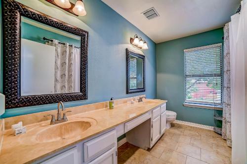 La salle de bains est pourvue d'un lavabo, d'un miroir et de toilettes. dans l'établissement Sunny Oasis, à San Antonio
