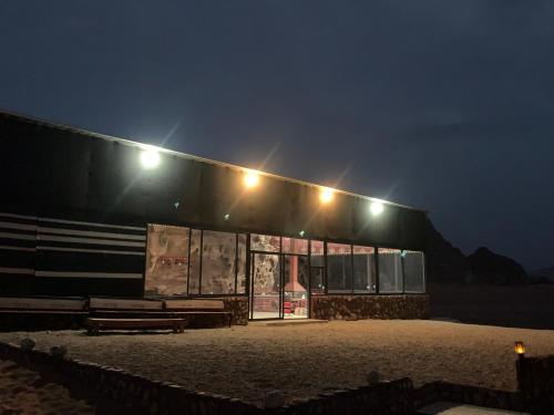 un edificio con luces por la noche en Wadi Rum Travel camp en Wadi Rum