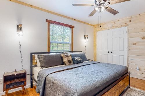 1 dormitorio con 1 cama y ventilador de techo en Ole Bud Cabin, en Sevierville