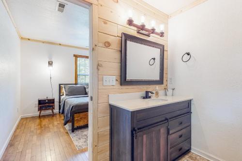 baño con lavabo, espejo y cama en Ole Bud Cabin, en Sevierville