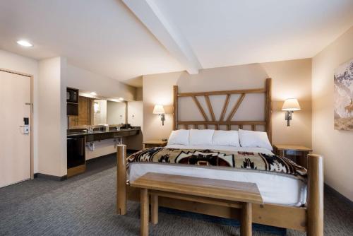 a bedroom with a large bed and a kitchen at Best Western Plus Kentwood Lodge in Sun Valley