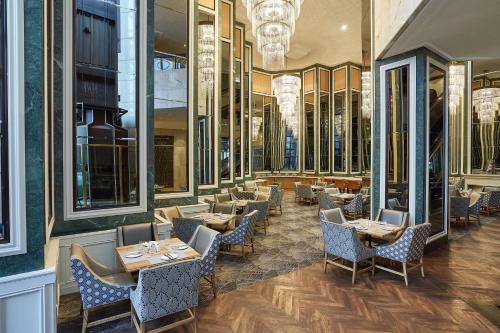 a restaurant with tables and chairs and mirrors at Southern Sun Cape Sun in Cape Town