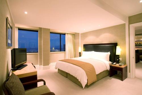 a hotel room with a bed and a television at Southern Sun Cape Sun in Cape Town