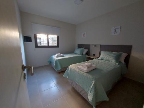 a bedroom with two beds and a window at Complejo El Olivo in San Martín