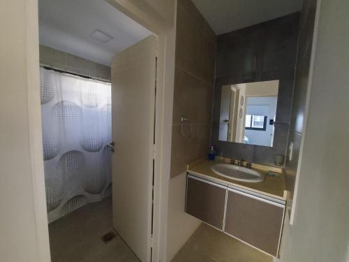 a bathroom with a sink and a mirror and a shower at Complejo El Olivo in San Martín