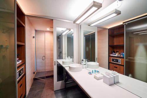 a bathroom with two sinks and two mirrors at Aloft Cleveland Airport in North Olmsted