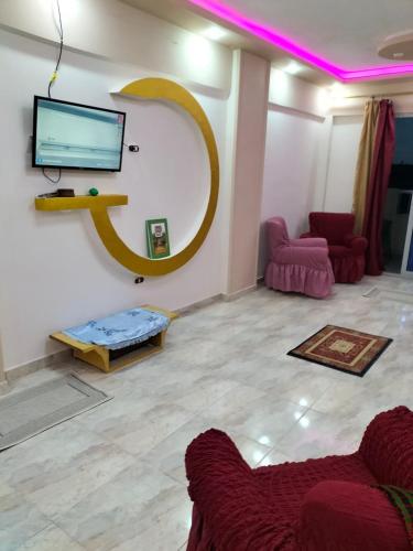 a living room with a couch and a tv on a wall at Flores casas de playa in Alexandria