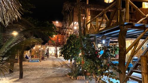 a building with a bunch of plants hanging from it at Hostal Olmito Canoa in Canoa