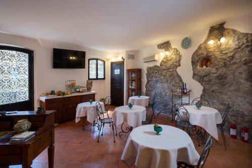 um restaurante com mesas e cadeiras e uma parede de pedra em B&B RE TANCREDI em Taormina
