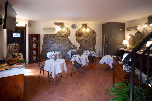 a restaurant with tables and chairs and a stone wall at B&B RE TANCREDI in Taormina