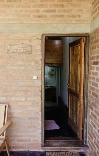 an open door to a room with a brick wall at Complejo Paranay in Puerto Paranay