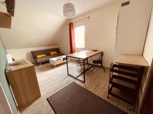 a small living room with a table and a couch at Le Clos Robinson in Martin-Église