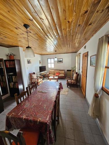a dining room with a table and a living room at La Casa de Kuky in Esquel