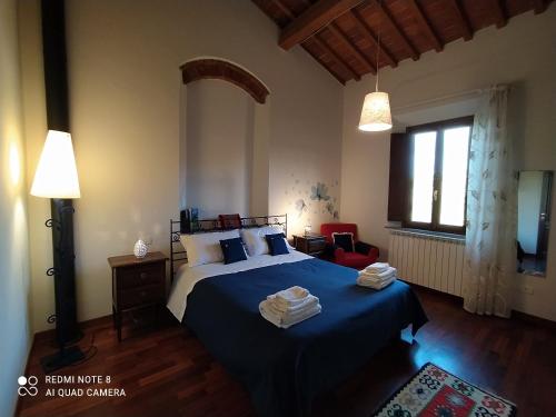 - une chambre avec un lit doté de draps bleus et une fenêtre dans l'établissement Casa Pina, à Malmantile