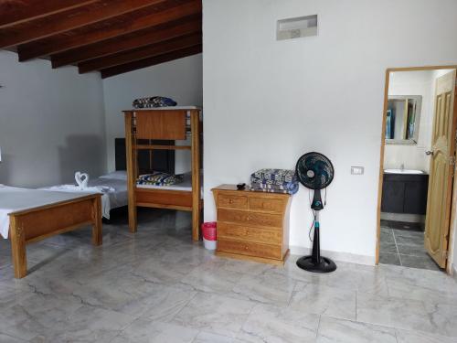 1 dormitorio con 1 cama, escritorio y ventilador en Hosteria Puerta del Nus en Cisneros