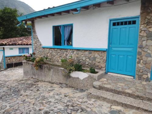 a house with a blue door and a window at Hosteria Puerta del Nus in Cisneros