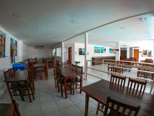 un restaurant vide avec des tables et des chaises en bois dans l'établissement Vila de Maré Hotel, à Porto de Galinhas