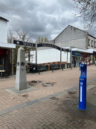 un panneau de rue au milieu d'une ville dans l'établissement West Highland Way Rooms ED30002F, à Milngavie