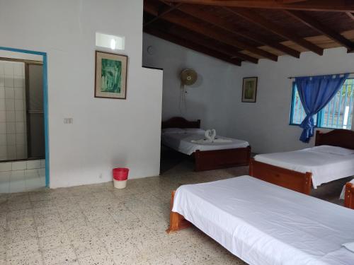 a room with two beds and a bathroom at Hosteria Puerta del Nus in Cisneros