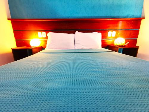 a bedroom with a bed with a blue and red headboard at Pousada Aquarela do Mar in Abraão