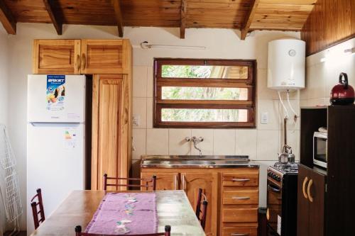 a kitchen with a table and a sink and a refrigerator at Complejo Paranay in Puerto Paranay